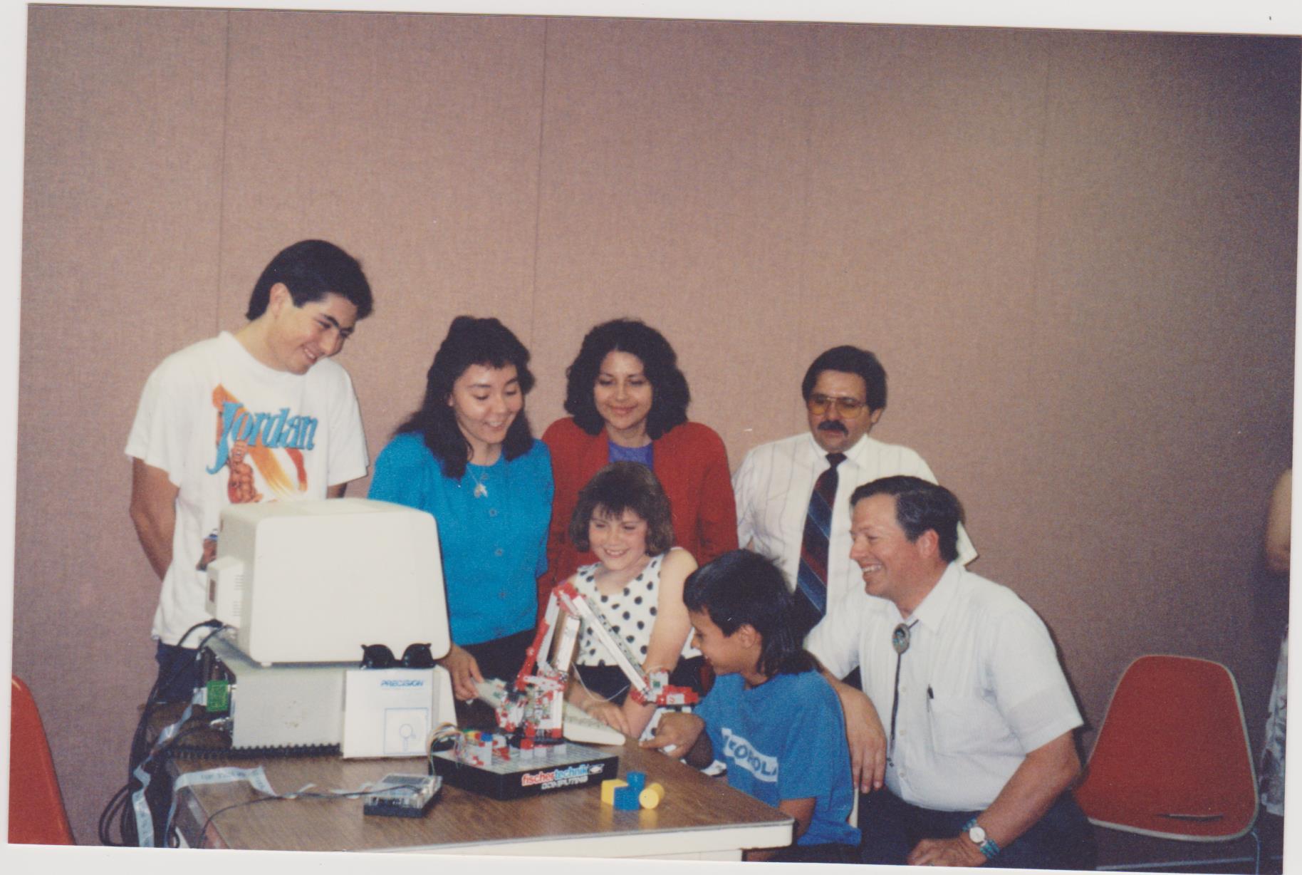 Our alumnus (far right) with colleagues, students, and the robot (Credit: Luna Community College LRC)
